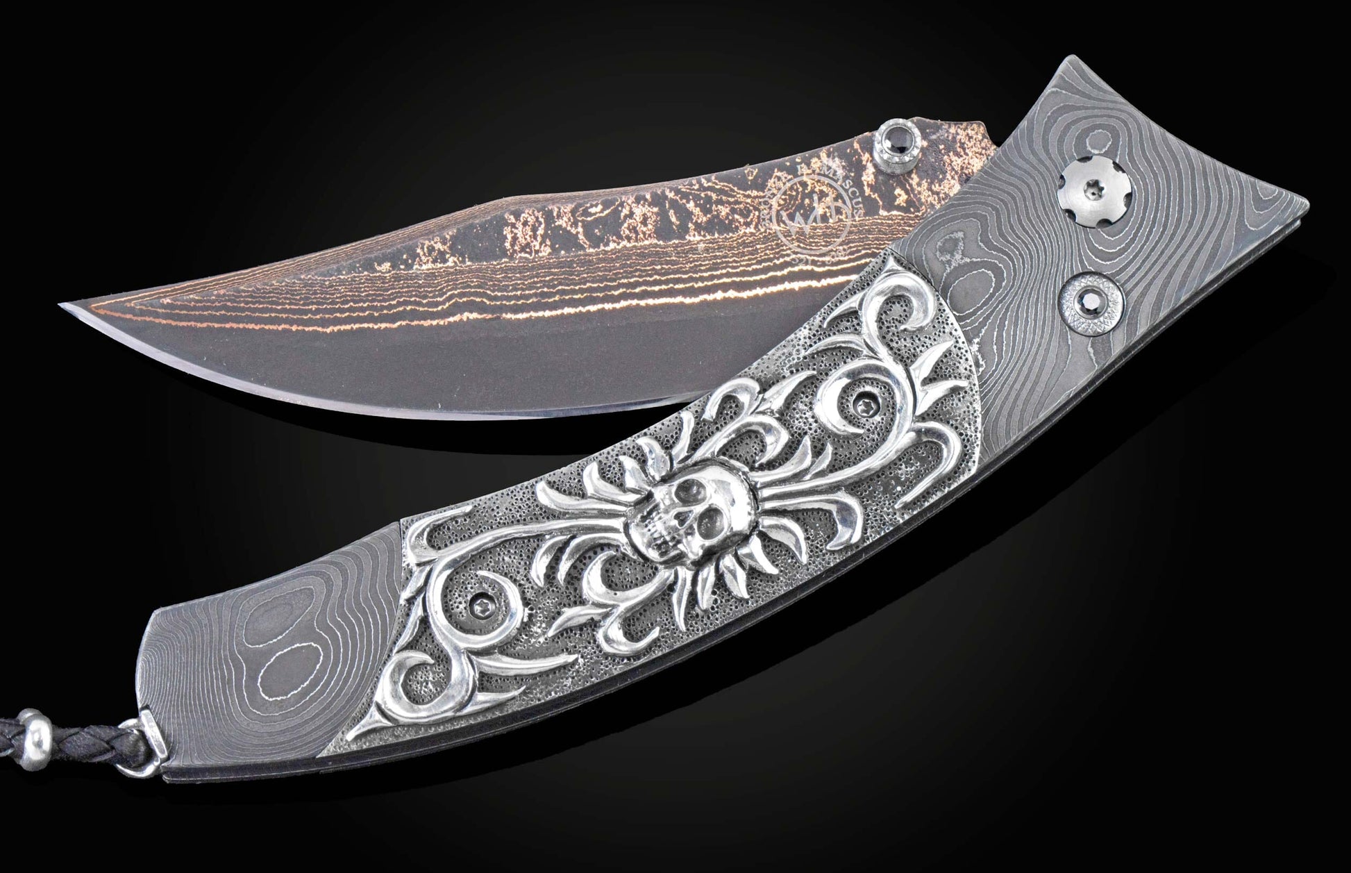 Custom William Henry knife featuring a frame in hand forged Damascus steel by Chad Nichols, inlaid with hand-carved sterling silver skull by Lee Downey, and a hand forged Damascus steel blade by Baker Forge.