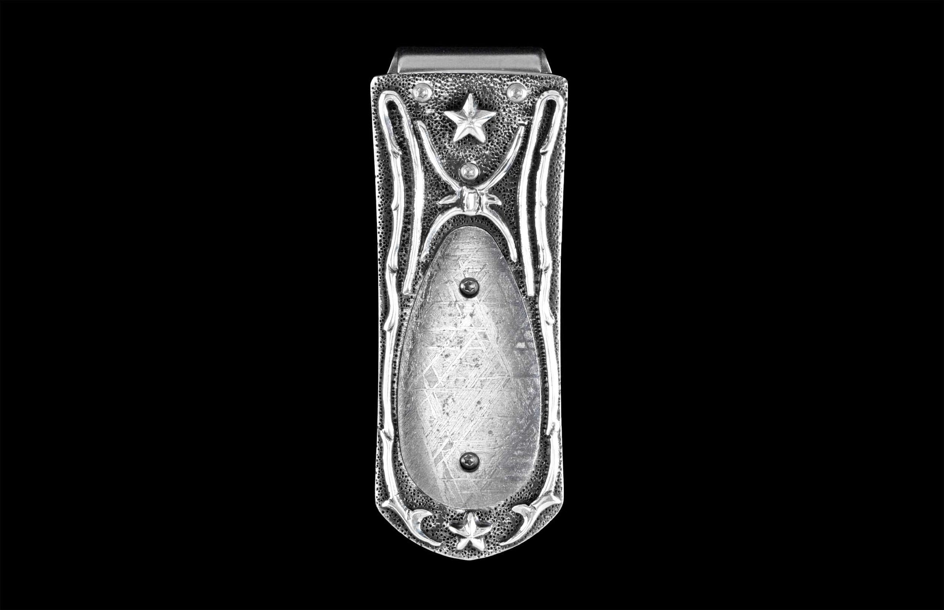Handcrafted luxury money clip from William Henry featuring hand-carved sterling silver inlaid with Gibeon meteorite scales.