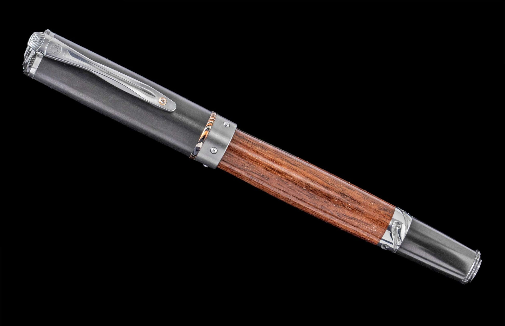 Handcrafted William Henry pen featuring a barrel of cherry wood from Churchill Downs Turf Club, titanium, aluminum, and a white topaz gemstone.